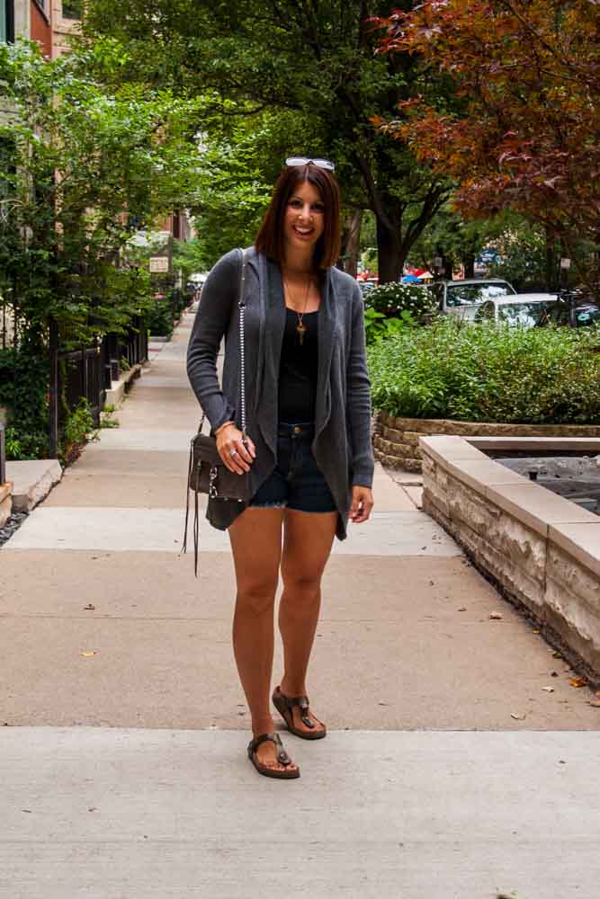woman in shorts and sweater and sharing Transitional Pieces Summer to Fall
