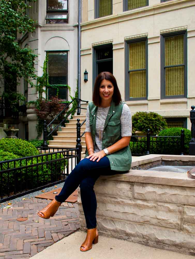 woman wearing grey shirt, jeans, and green vest for Currently Loving September Edition