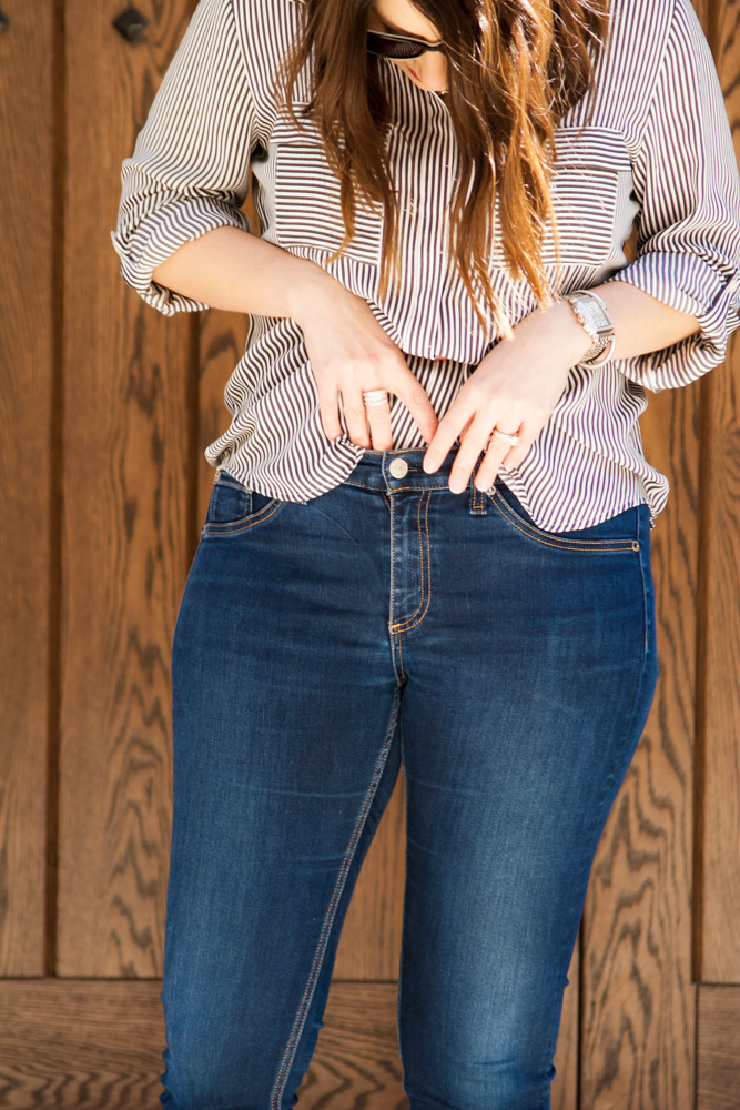 woman inserting shirt in her jeans 