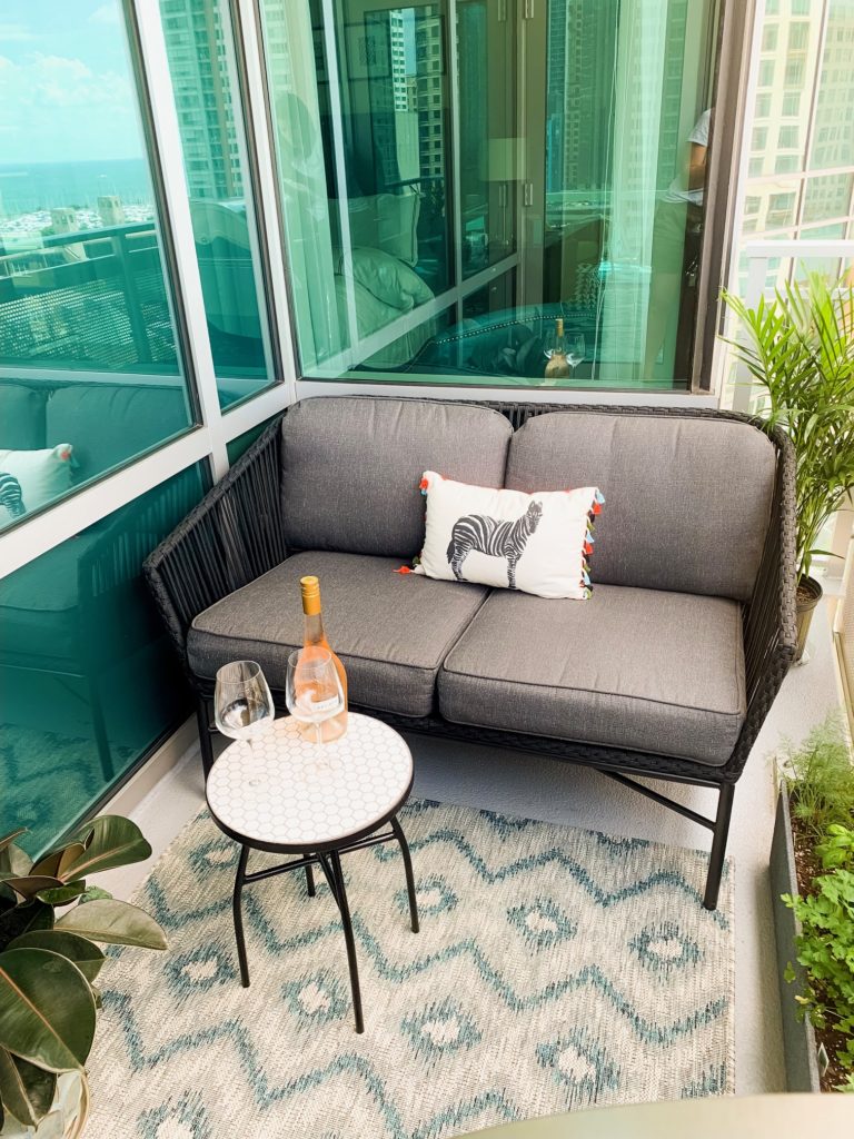 a table with wine and wine glass and chair in a Small Outdoor Patio