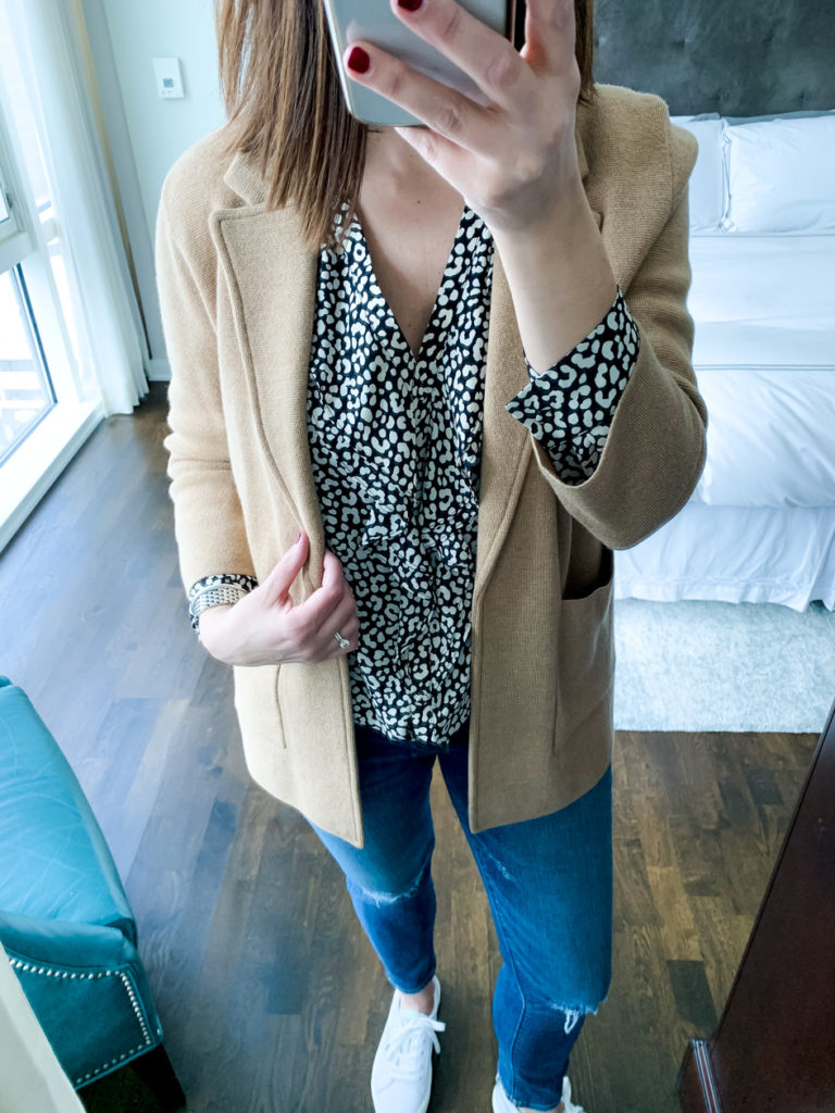 closer look of woman wearing black and white leopard print ruffle, skirt, jacket, and denim pants which is one of the ways to wear one top 3 ways 