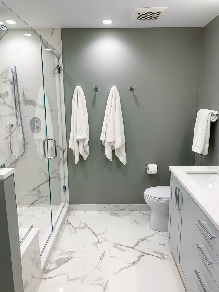 bath towels hanging on the wall, sink, and toilet bowl