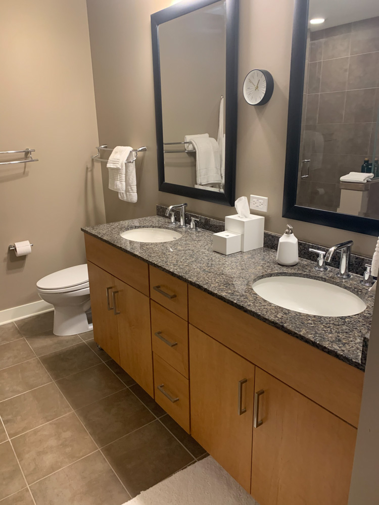 bathroom sinks, toiletries, cabinets and white toilet bowl