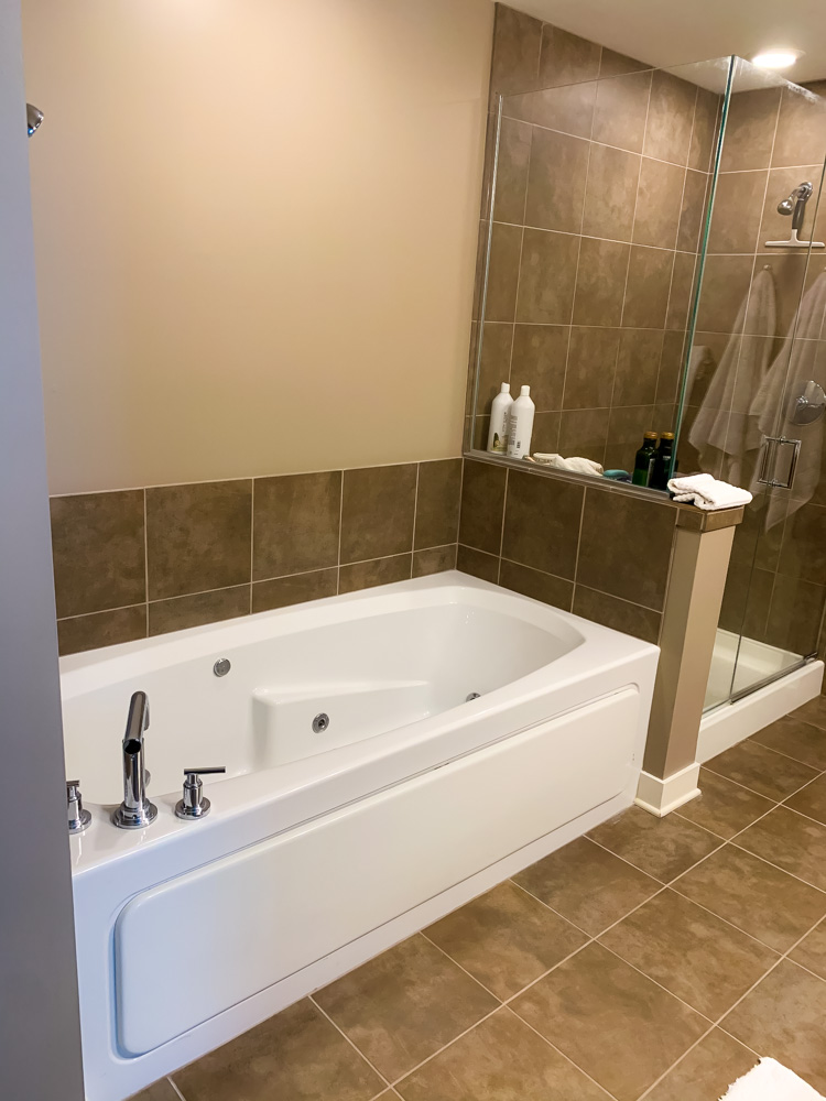 white bath tub and brown tiles