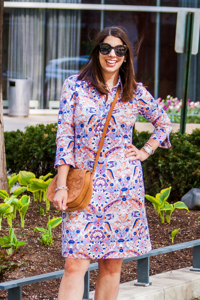 woman hand on her waist, smiling, and wearing patterned dresses for spring