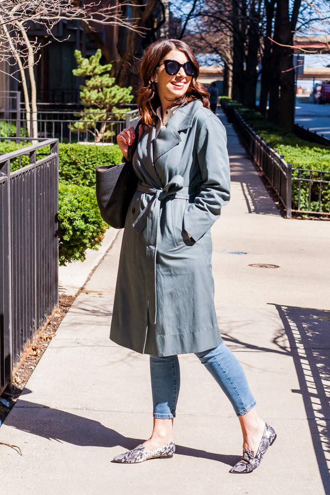 woman wearing closed unique trench coat in green and sunglasses