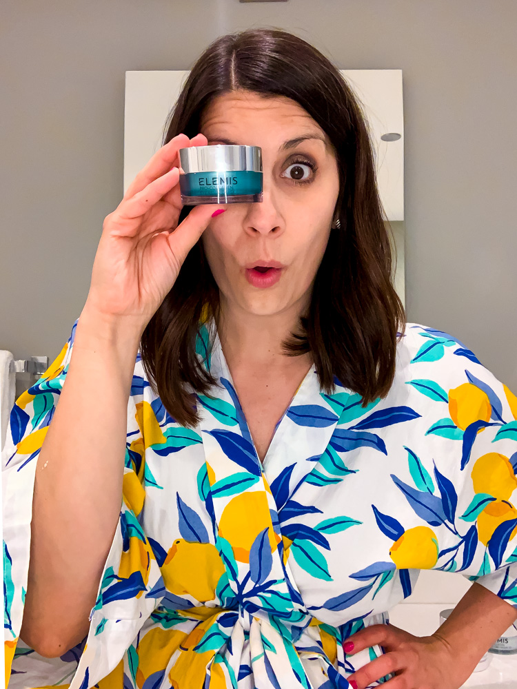 woman holding a product of ELEMIS beauty routine near her eye