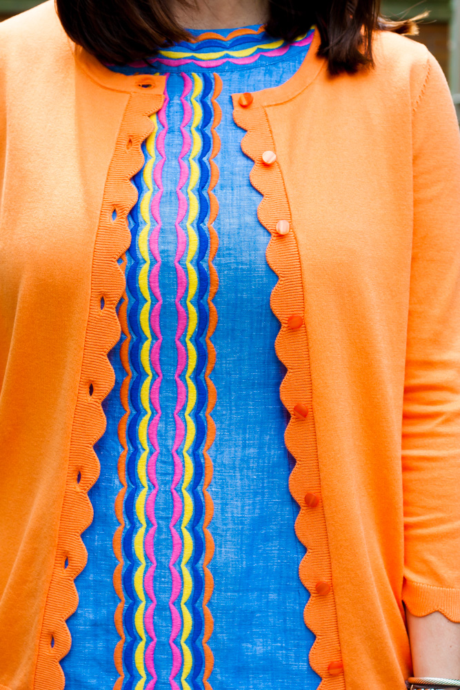 woman wearing blue dress and orange cardigan