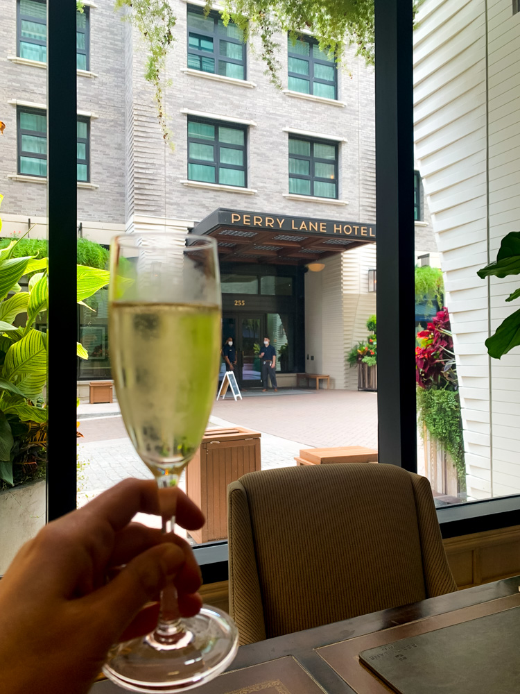 person holding wine glass against perry lane hotel in Savannah Travel Guide