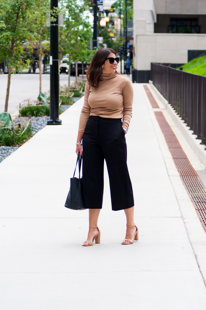 woman wearing turtle neck top and black pants for post pandemic outfits