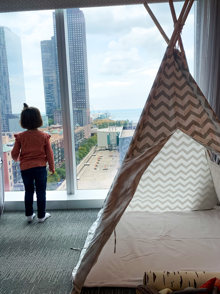 child looking out the window from a room at the Loews Chicago Hotel