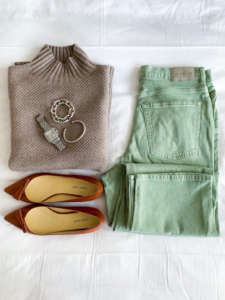 flat lay of green straight leg denim, brown flats, and sweater 