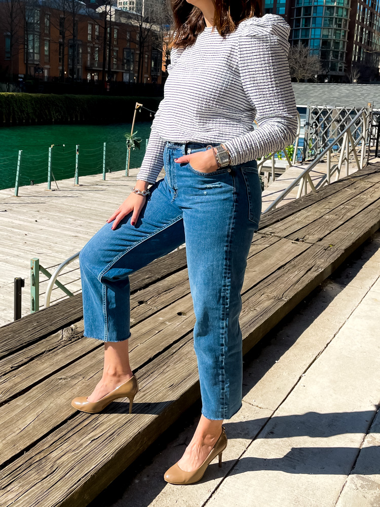 Woman wearing straight leg denim jeans and black and white top