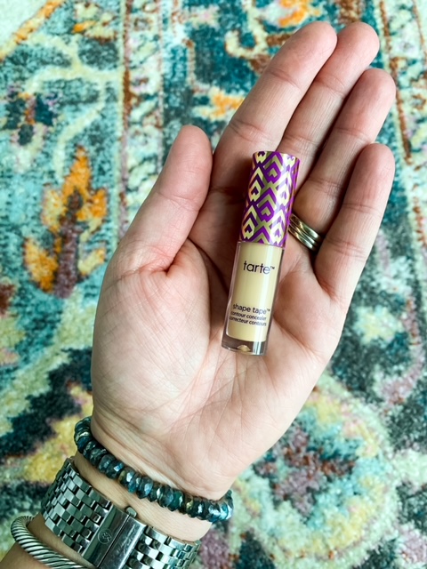 woman holding tarte cosmetics concealer