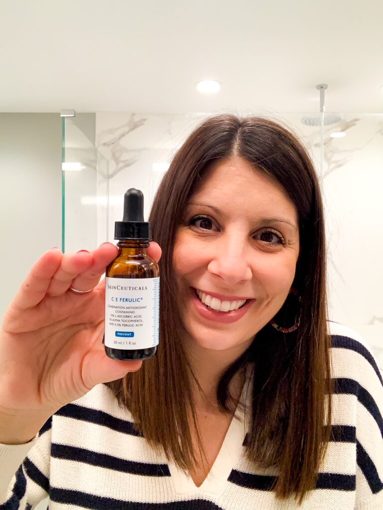 woman holding bottle of skinceuticals C E Ferulic