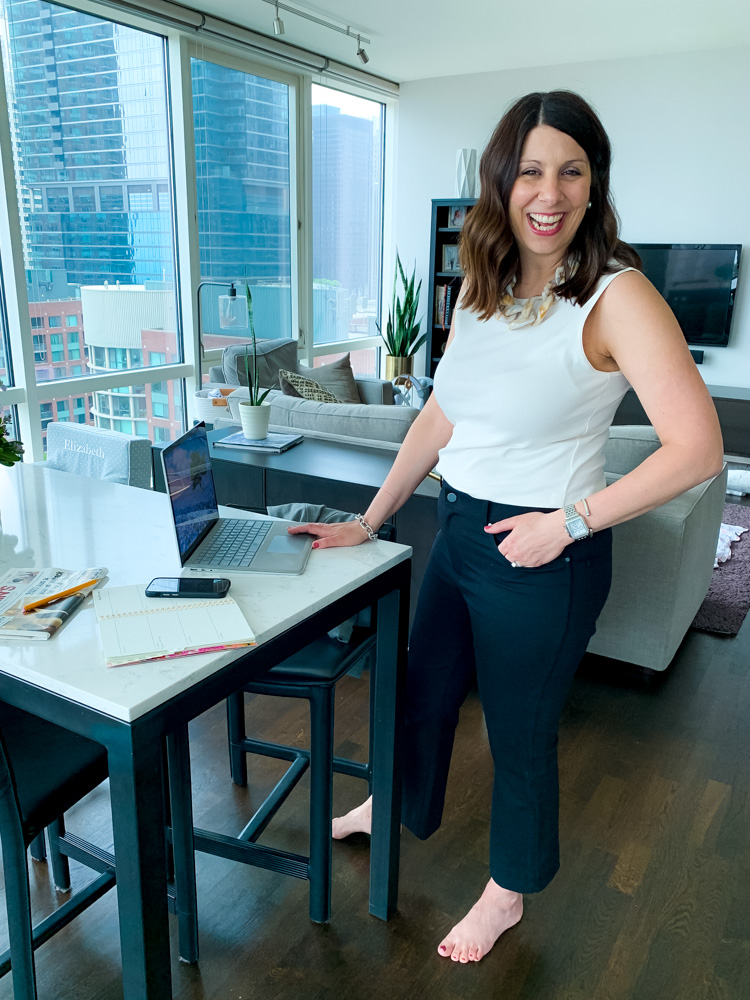 woman wearing work from home uniform using her laptop and smiling