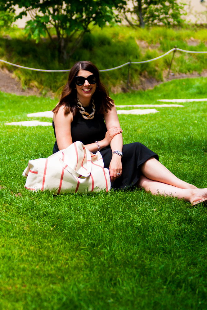 woman sitting on grass with her summer tote bag