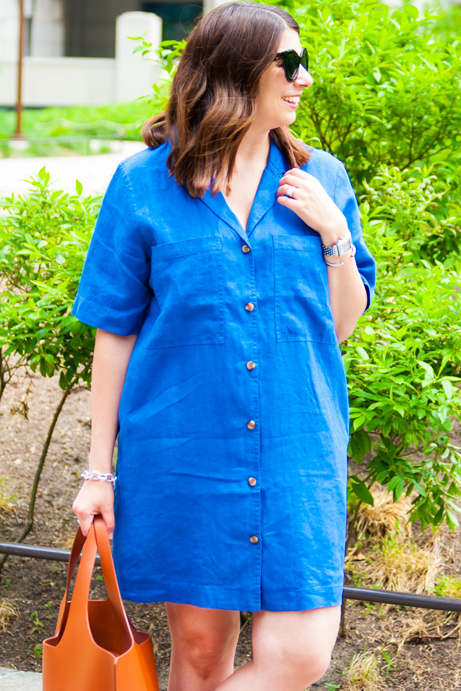 woman wearing a summer travel outfit in blue and wearing sunglasses