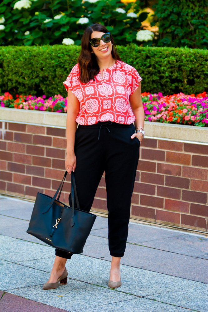 woman in one of her summer work tops, black pants, and nude pumps