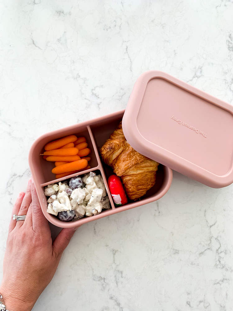 bento box work lunch featuring carrots and a croissant