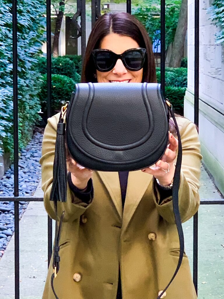 woman holding her black saddle bag