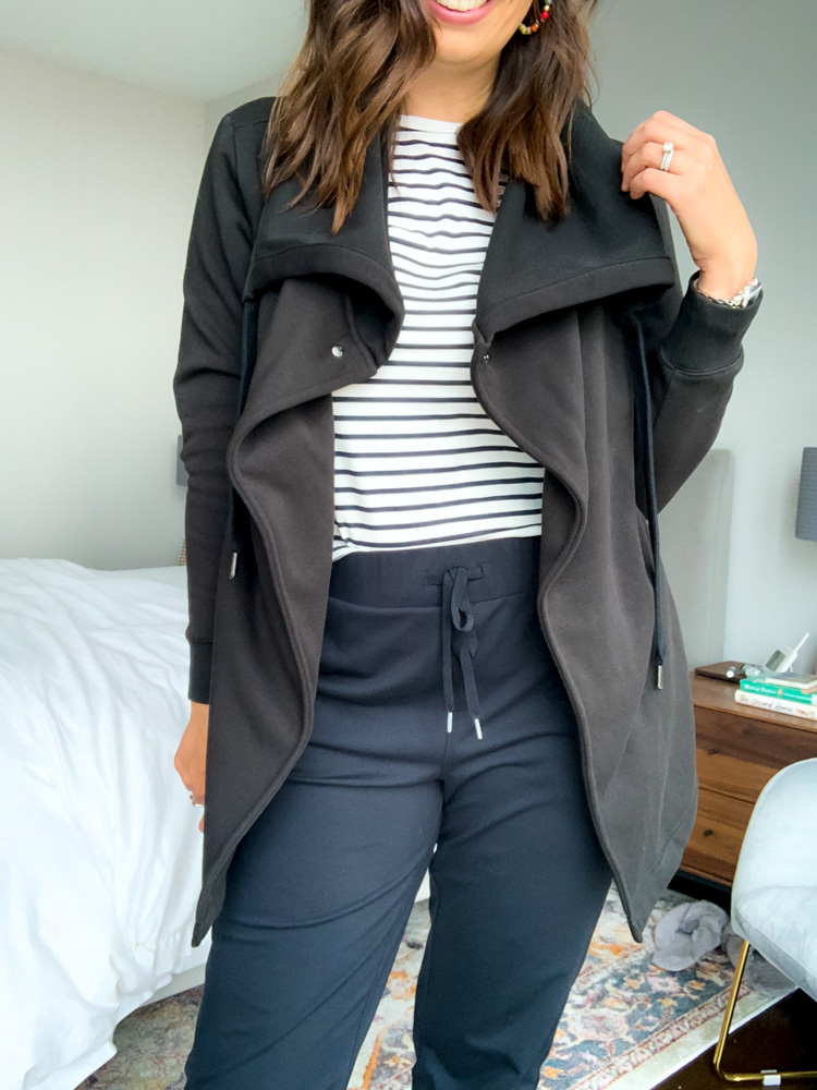 woman in bedroom wearing athleisure jacket and pants for outfit for mom 