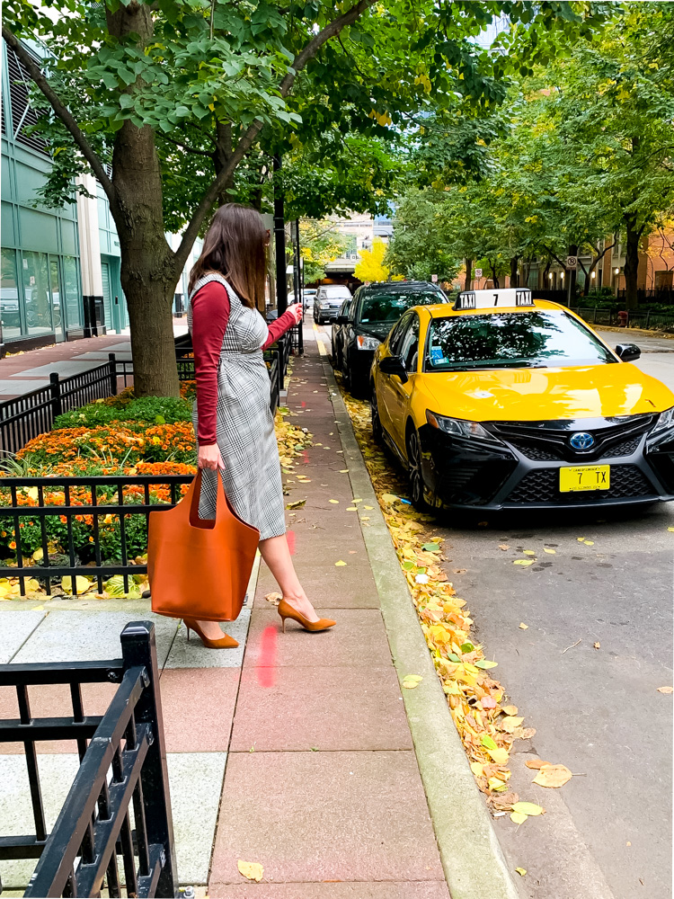 Woman walking and showing how to wear plaid this fall