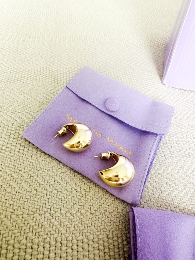 A pair of She’s So Smooth Teardrop Hoops by Melinda Maria—sleek, modern, and versatile gold hoop earrings for any occasion