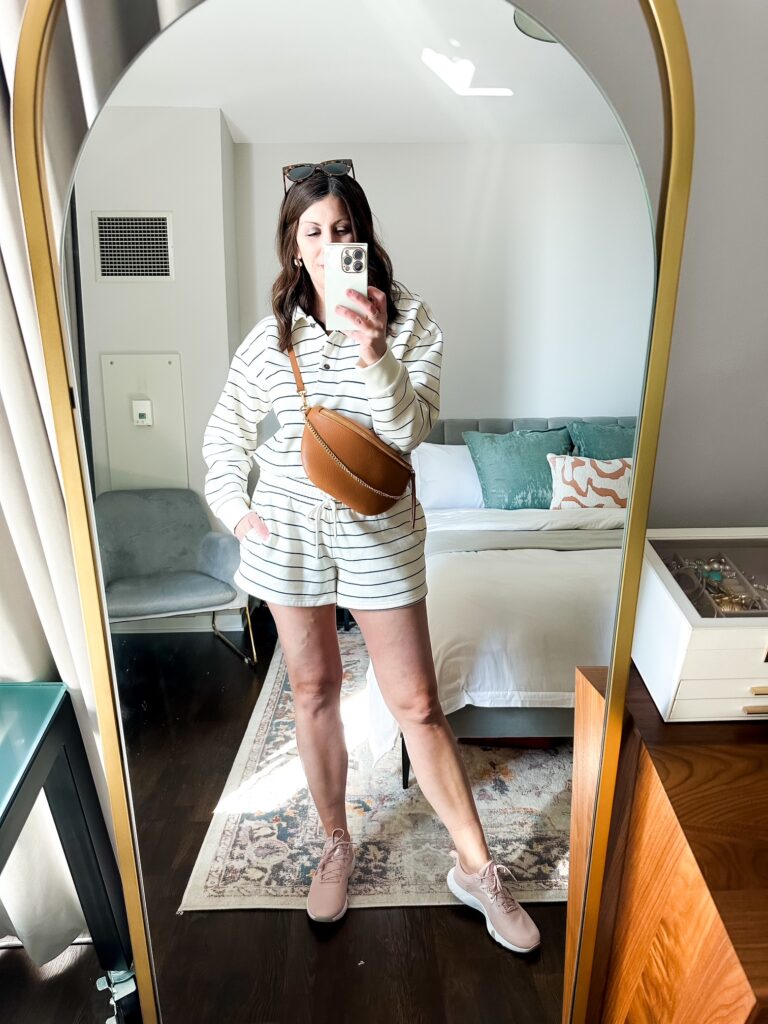 A casual athleisure outfit featuring shorts, a sweatshirt, and slip-on sneakers.