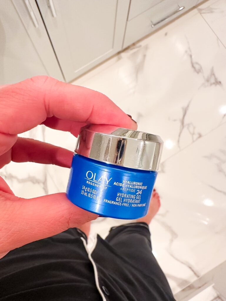 Flatlay of four affordable skincare bottles and jars on a neutral marble background